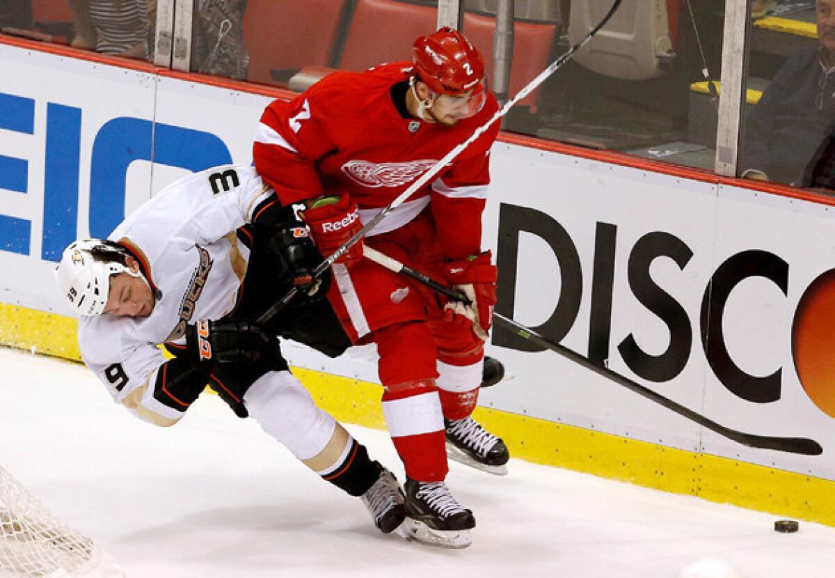 Detroit Red Wings' Brendan Smith controls the puck as Anaheim Ducks' Matt Beleskey falls to the ice.