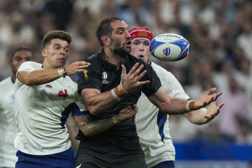 New Zealand's Samuel Whitelock, center, fights for the ball with France's Matthieu Jalibert, left, during the Rugby World Cup Pool A match between France and New Zealand at the Stade de France in Saint-Denis, north of Paris, Friday, Sept. 8, 2023. (AP Photo/Lewis Joly)