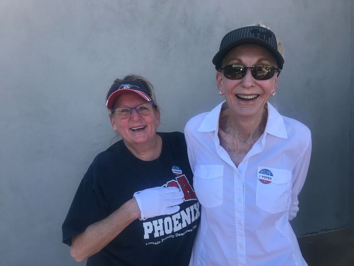 Donnette Hermes and Susan Stewart stand together at a south Phoenix strip mall.