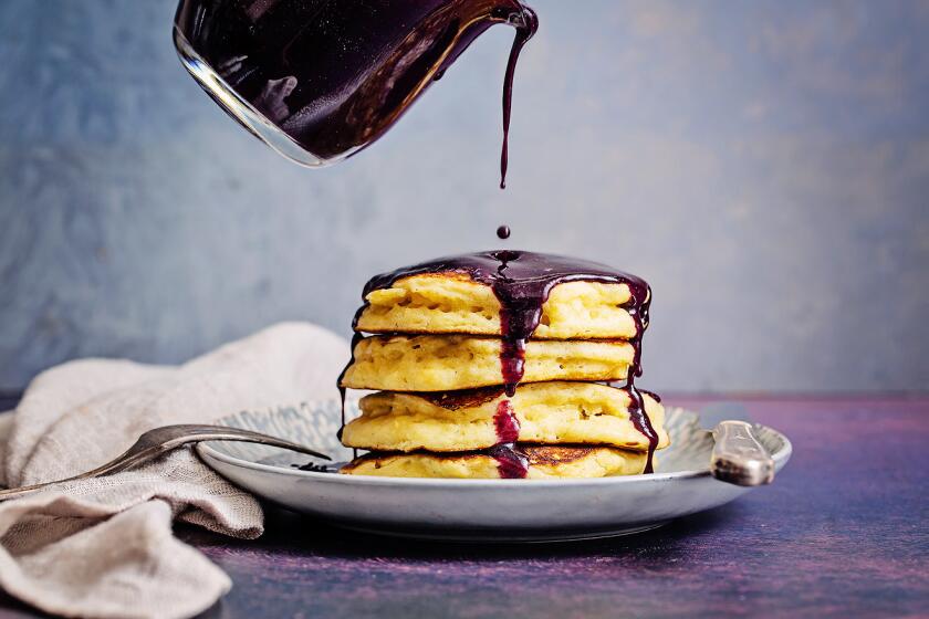A stack of pancakes with blueberry maple syrup.
