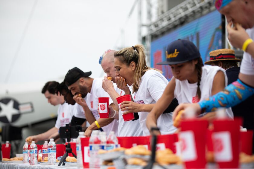 Competitive eaters participate in the fifth annual National Donut Day World Donut-Eating Championship aboard the USS Midway on Friday, June 2, 2023. The event, hosted by The Salvation Army, raised funds for veteran services in the greater Los Angeles area.