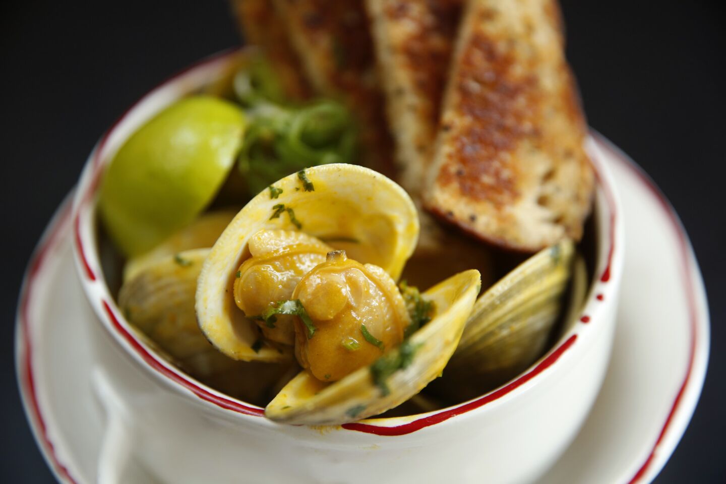 Clams sudado: clams, sudado fish stew, aji amarillo chili lime broth.
