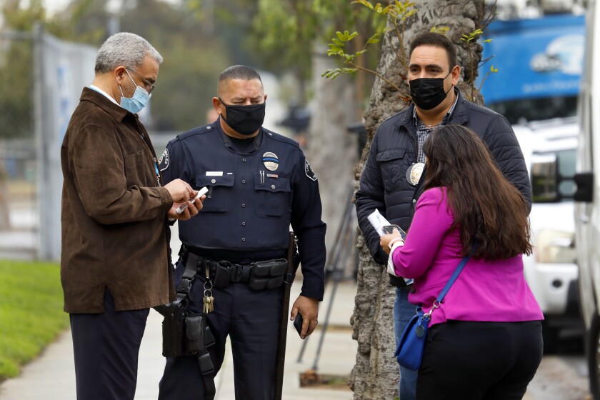 Los Angeles school police and school officials talk in front of Wilmington Park Elementary on Tuesday