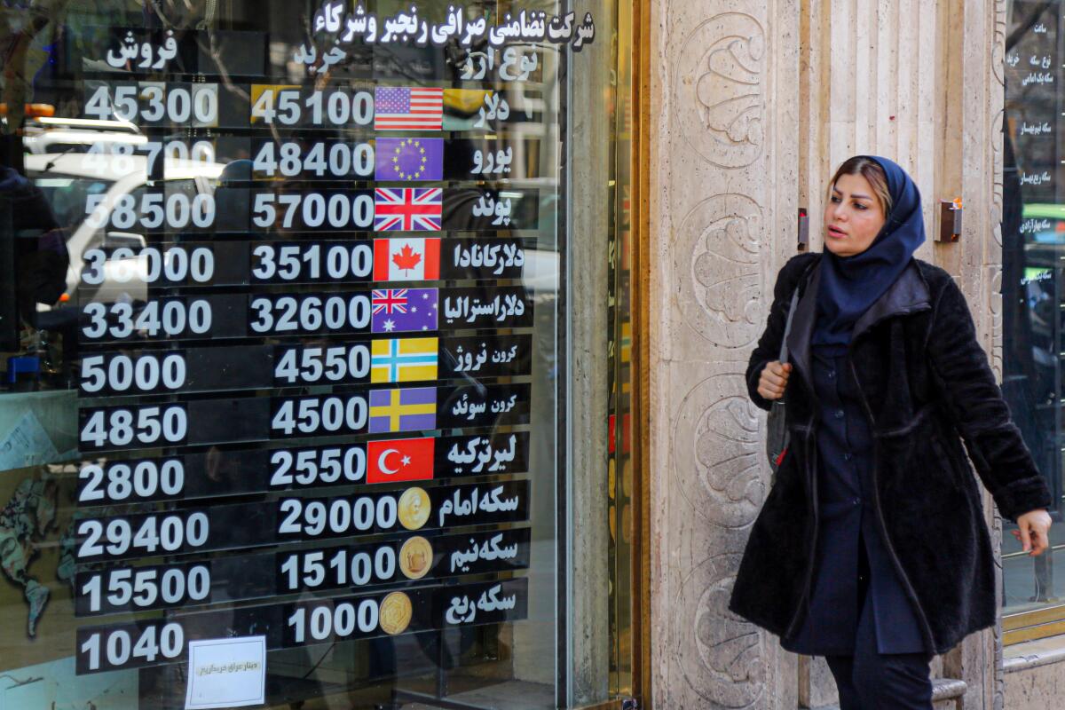 Woman looking at screen with foreign exchange rates in Tehran