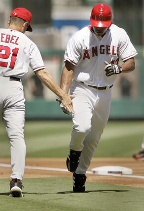 Angel Howie Kendrick gets a hand from coach Dino Ebel as he rounds third on a solo homerun in the second inning.