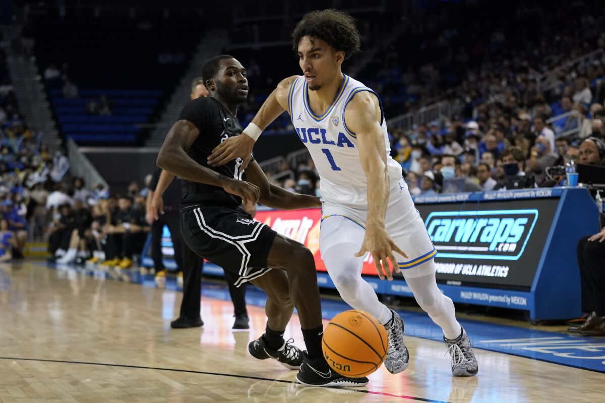 Long Beach State guard Joel Murray (11) defends against UCLA guard Jules Bernard (1) during the second half of an NCAA college basketball game in Los Angeles, Monday, Nov. 15, 2021. (AP Photo/Ashley Landis)