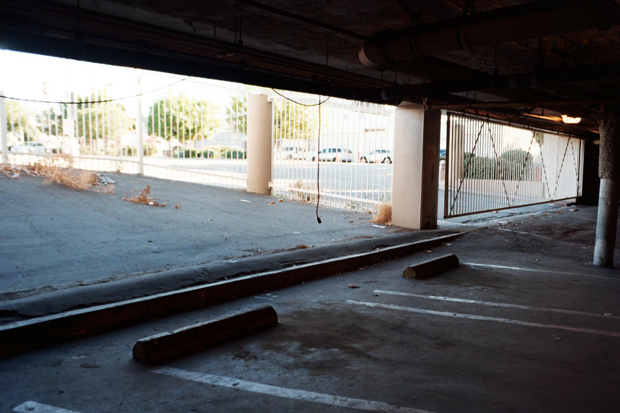 A gated, abandoned parking garage with an outdoor area