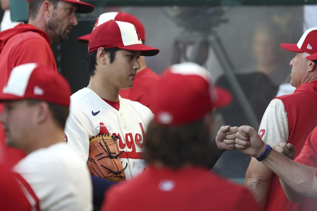 Angels starter Shohei Ohtani fist-bumps a teammate at the end of the first inning Sept. 3, 2022.