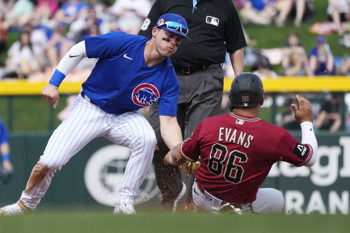 Chicago Cubs second baseman Nico Hoerner, left, tags out Arizona Diamondbacks' Phillip Evans (86) attempting to steal second base during the second inning of a spring training baseball game Thursday, March 16, 2023, in Mesa, Ariz. (AP Photo/Ross D. Franklin)