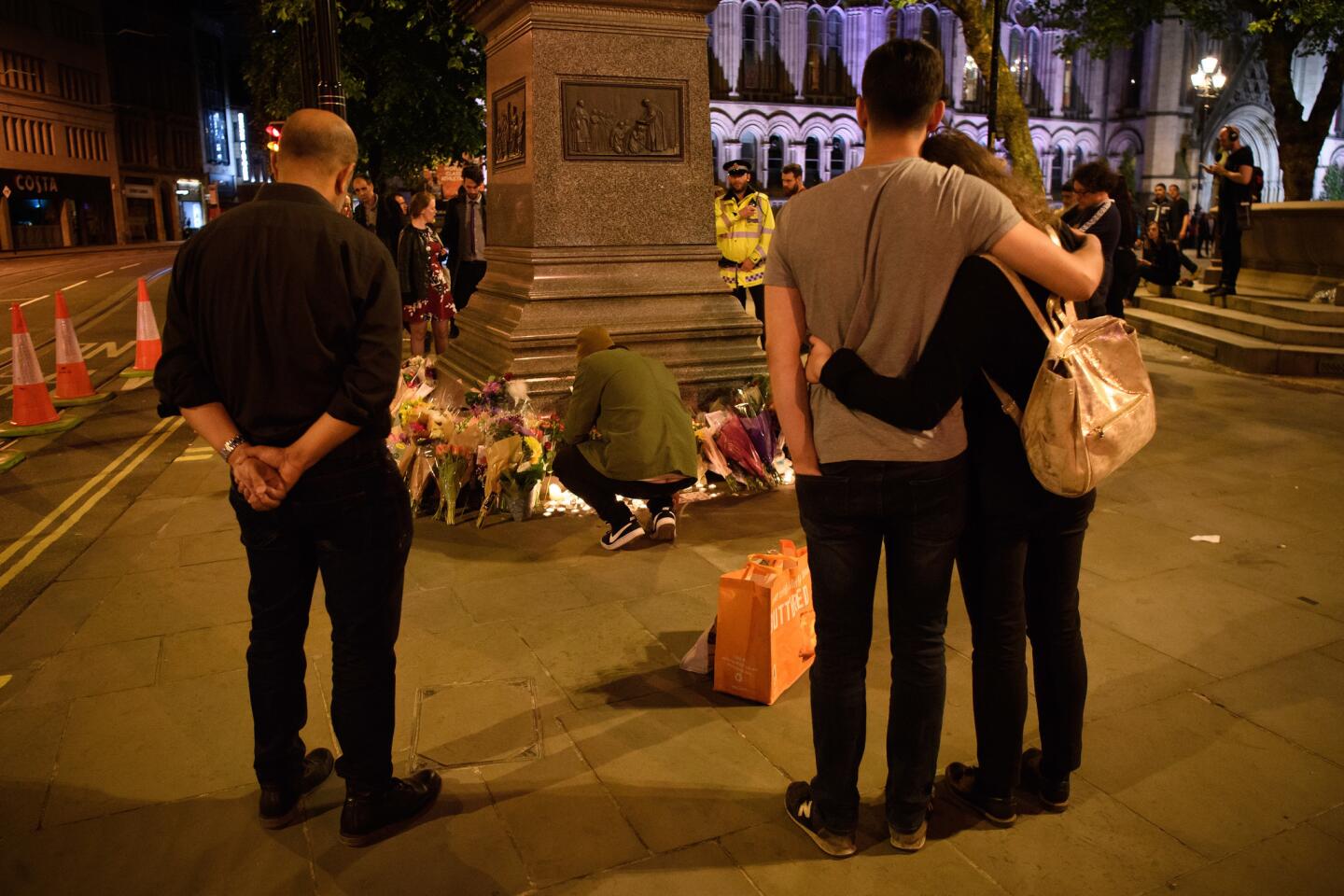 Visitors look at floral tributes after an evening vigil outside Town Hall on May 23, 2017, in Manchester, England. An explosion occurred at Manchester Arena as concertgoers were leaving an Ariana Grande performance.
