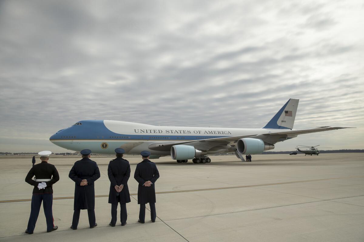 ARCHIVO - Personal militar observa cómo el Air Force One, con el presidente Donald Trump a bordo, 