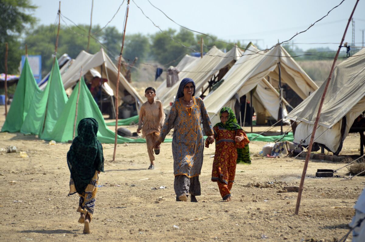 Familias caminan por un campamento de refugiados tras abandonar sus casas 