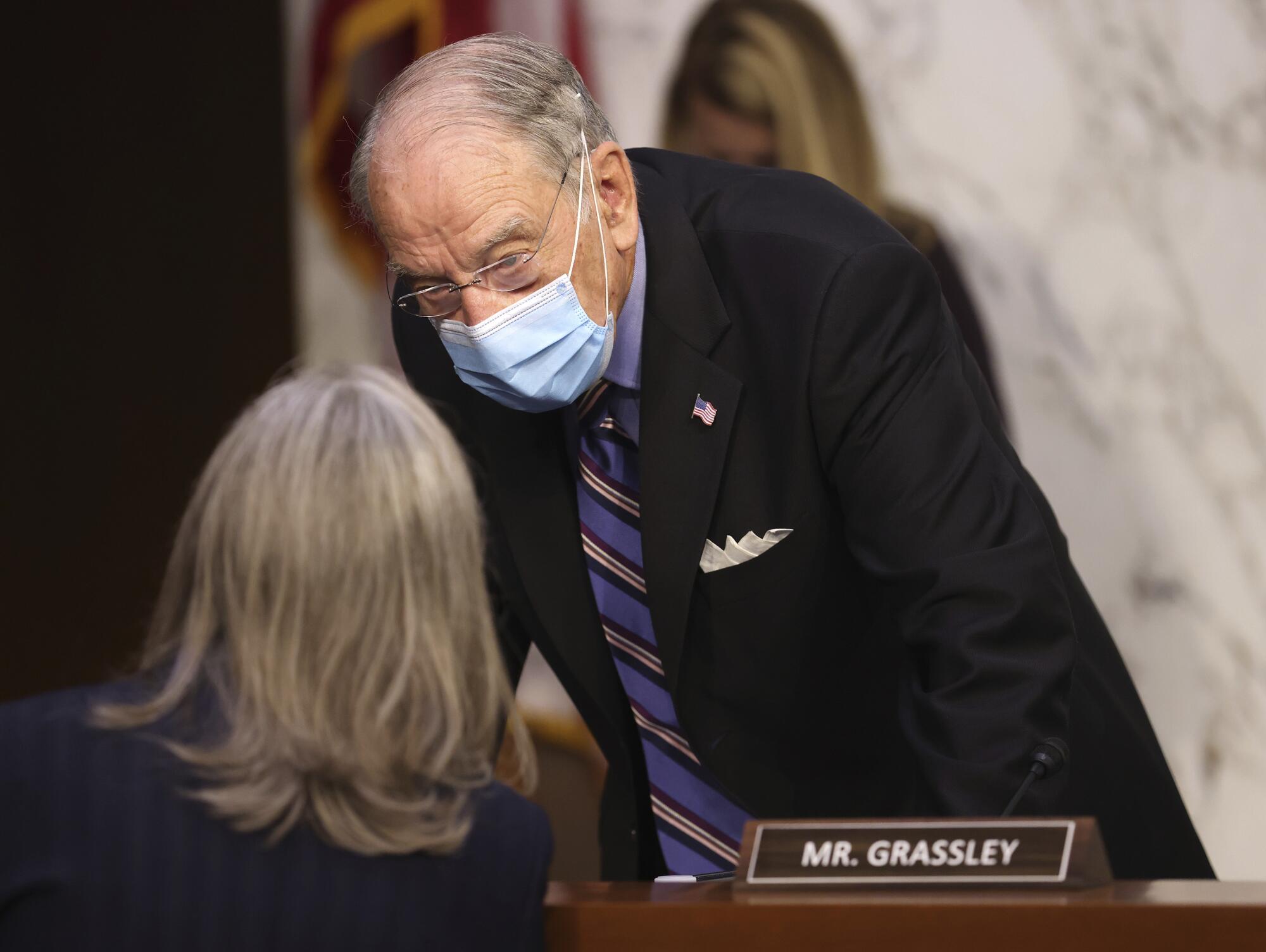 Sen. Chuck Grassley chats with a woman prior to the start of the hearing.