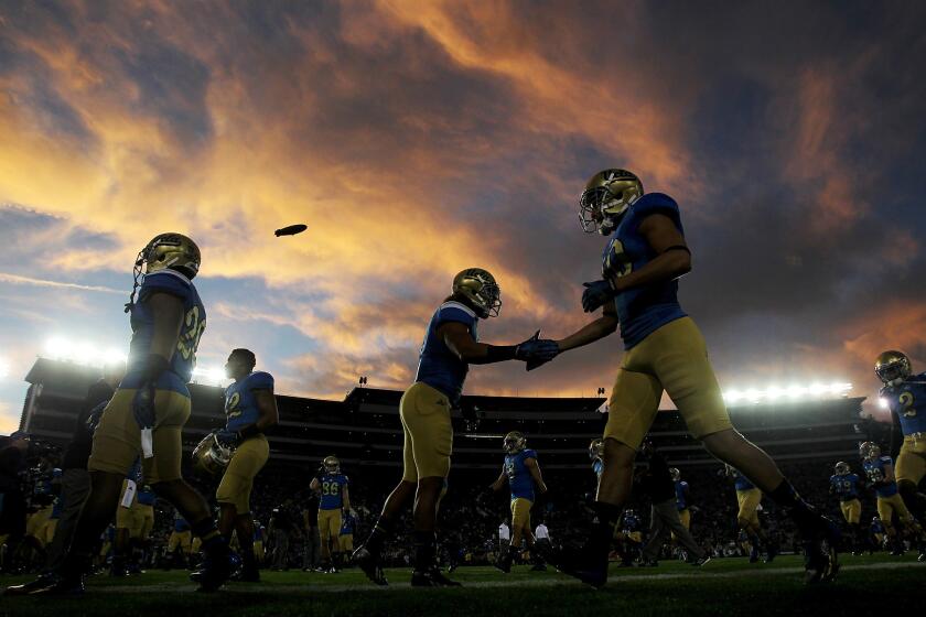 UCLA players warm up before the start of a game against crosstown rival USC on Saturday at the Rose Bowl.