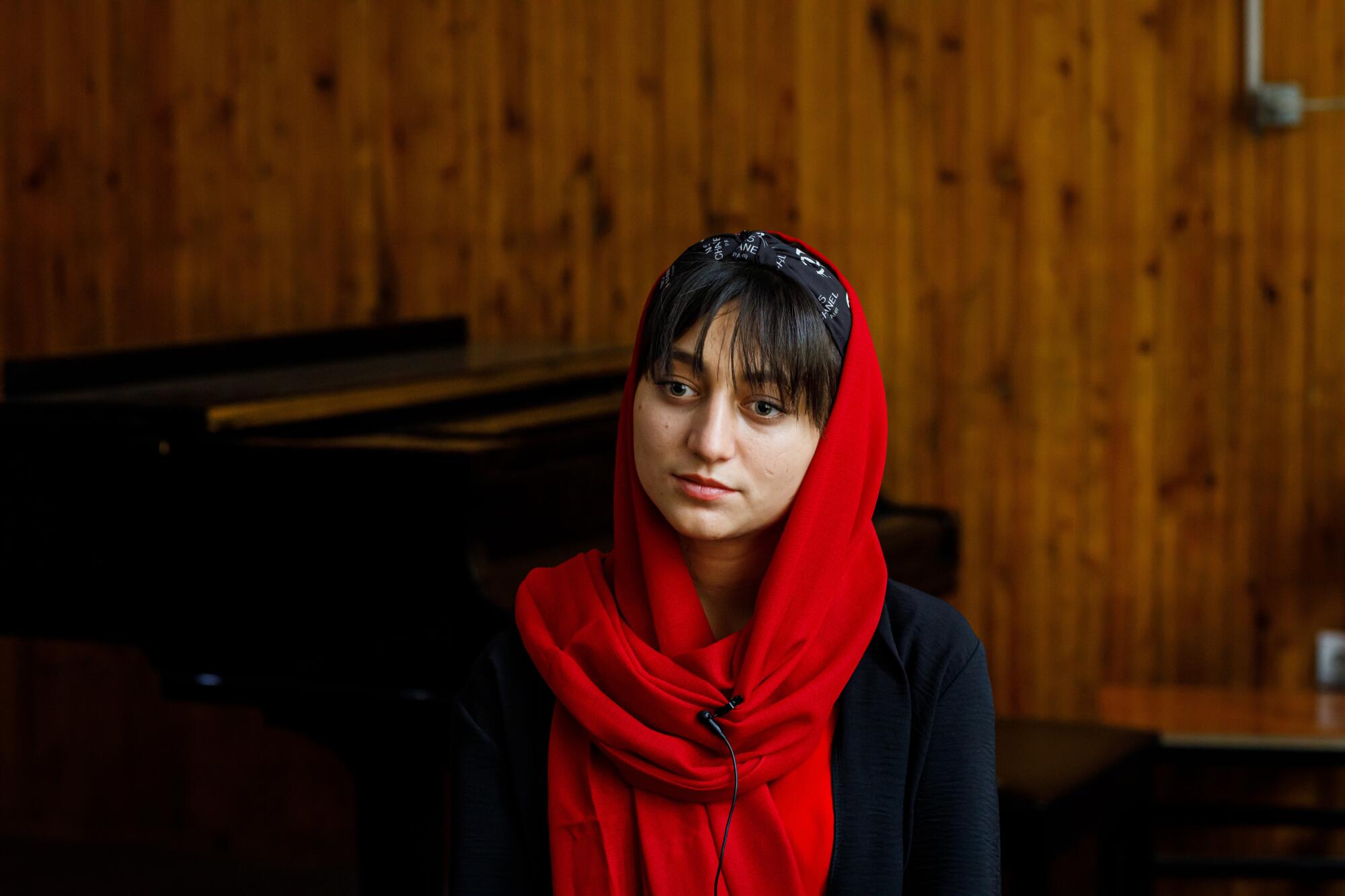 A young female musician wearing red and black.