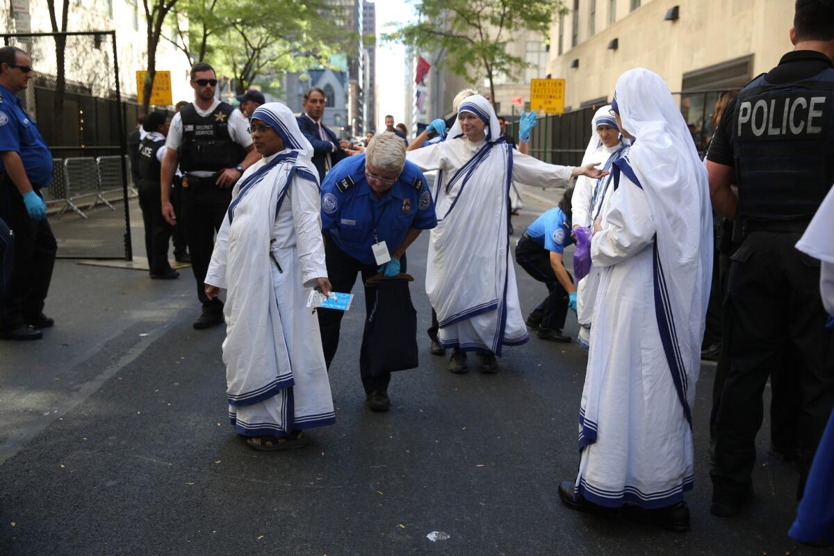Un policía de la ciudad de Nueva York catea a una monja afuera de la Catedral de San Patricio antes de la llegada del papa Francisco, el jueves 24 de septiembre de 2015 en Nueva York.