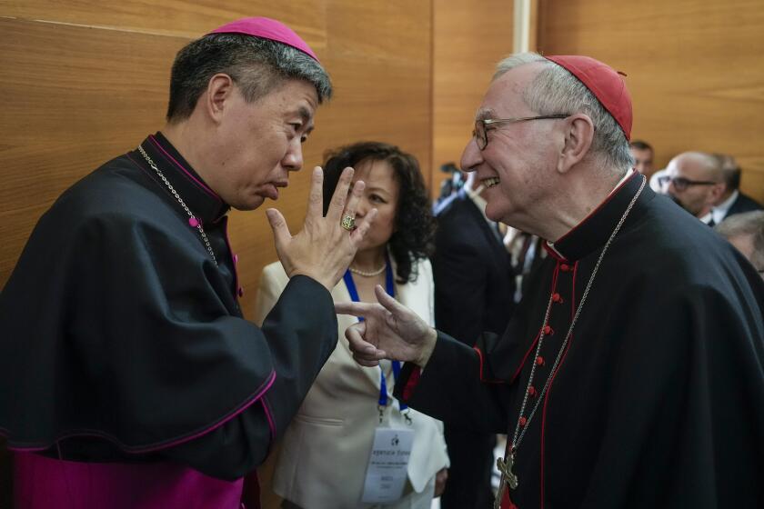 Shangai Bishop Joseph Shen Bin, left, talks with Vatican Secretary of State, Cardinal Pietro Parolin during an international conference to celebrate "100 years since the Concilium Sinense: between history and the present" celebrating the First Council of the Catholic Church in China, organized by the Pontifical Urbaniana University, in Verona, Italy, Tuesday, May 21, 2024. (AP Photo/Gregorio Borgia)