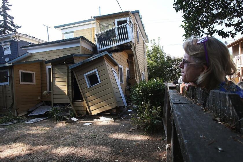 A woman eyees a red-tagged home near downtown Napa after a magnitude 6.0 earthquake in August 2014. An early alert system gave a 10-second warning before the quake hit.