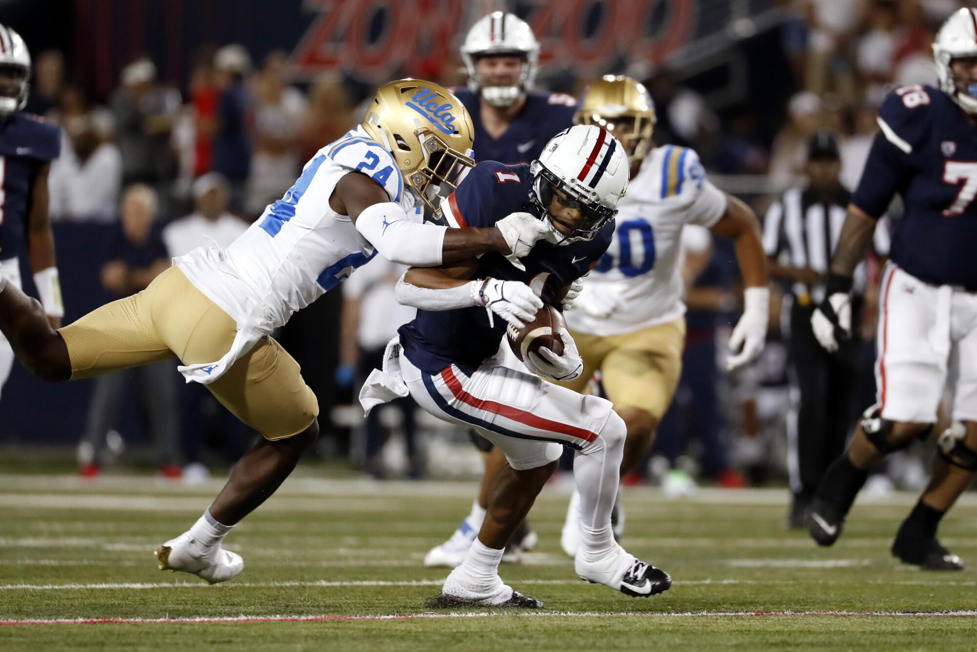 Arizona wide receiver Stanley Berryhill III is tackled by UCLA defensive back Qwuantrezz Knight