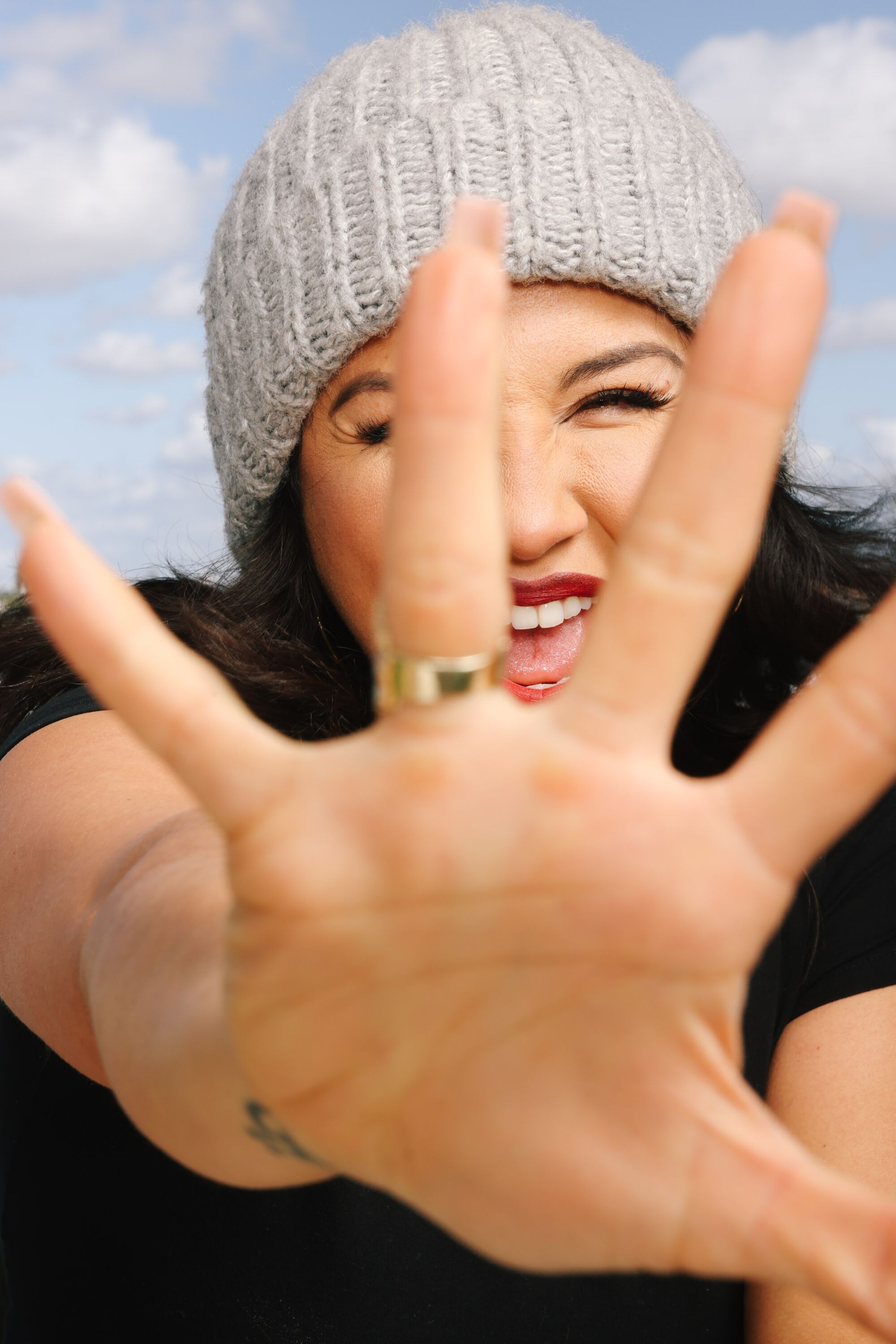 A woman holds her hand up to the camera.