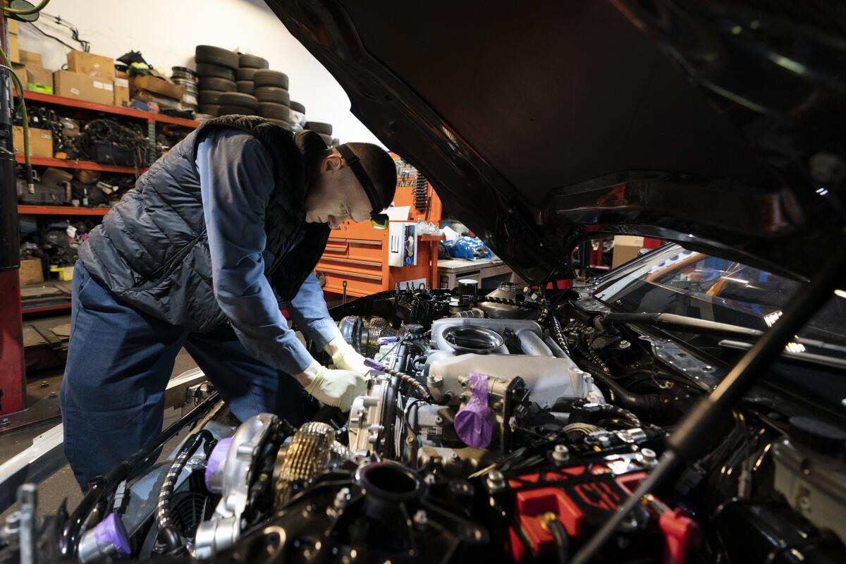 Mechanic David Stoliaruk works on the engine of a car at IC Auto in Philadelphia.