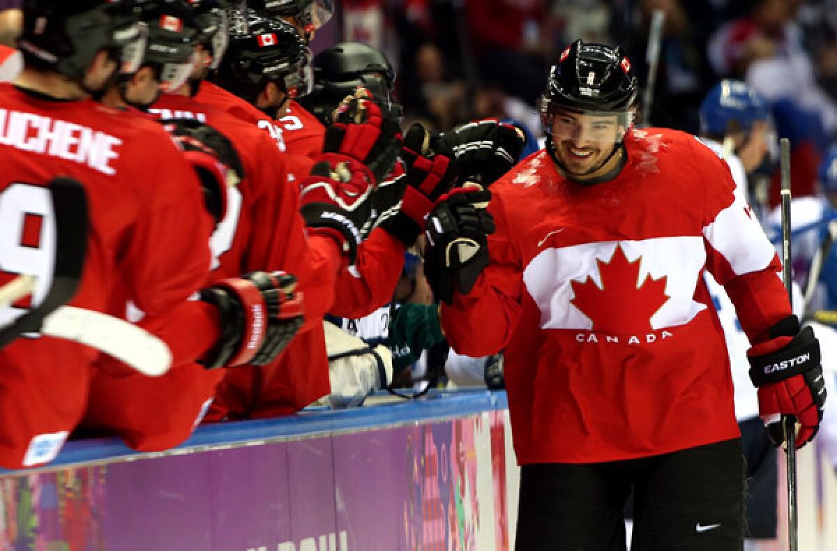 Canada defenseman Drew Doughty is congratulated by teammates after scoring a goal in the first period against Finland in a preliminary-round game of the Sochi Olympics on Sunday.