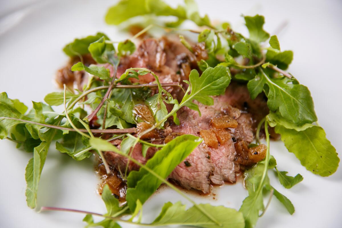 Veal with arugula served at Salt's Cure restaurant in Los Angeles.