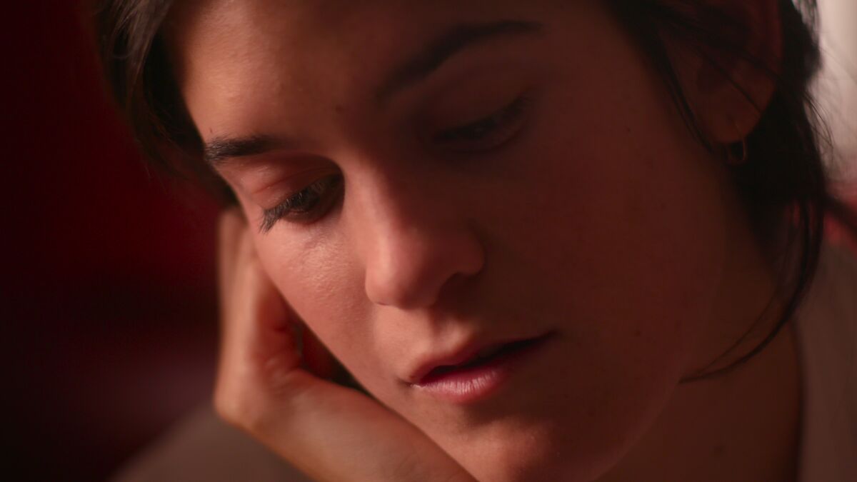 A close-up of a young woman's pensive face.