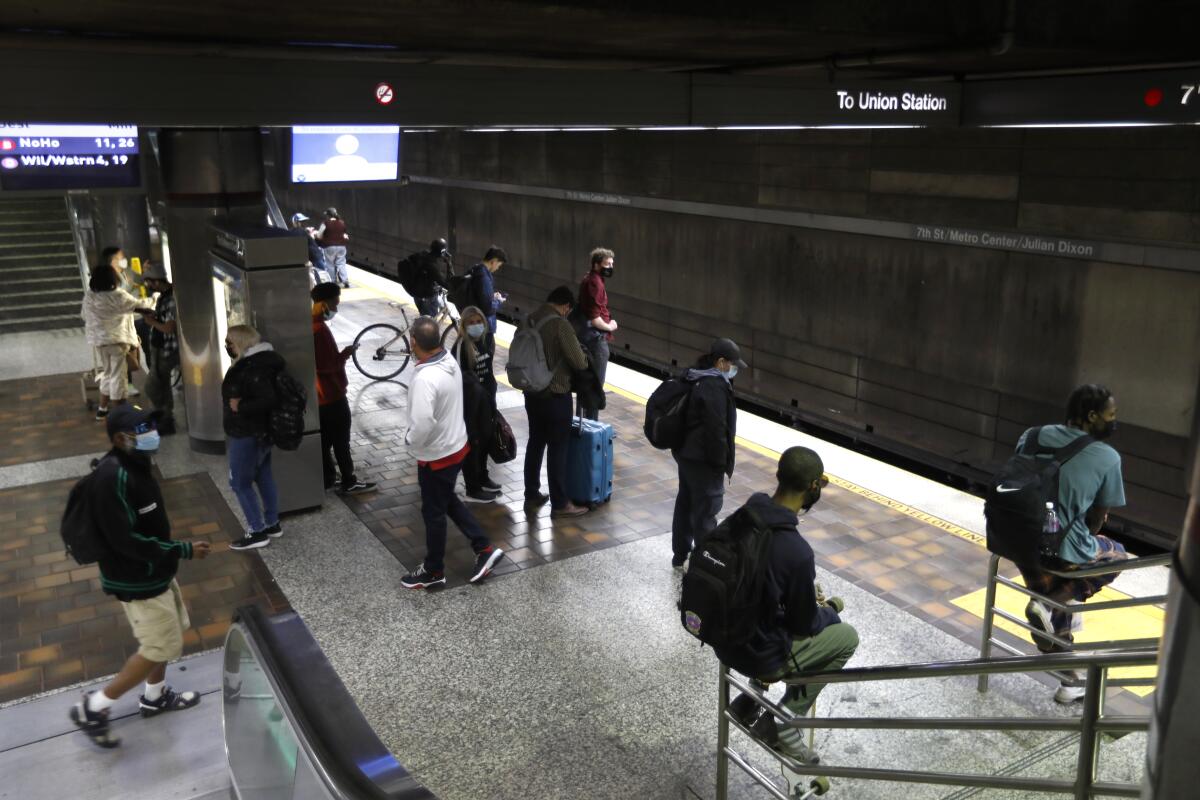 Metro riders wait at a station.