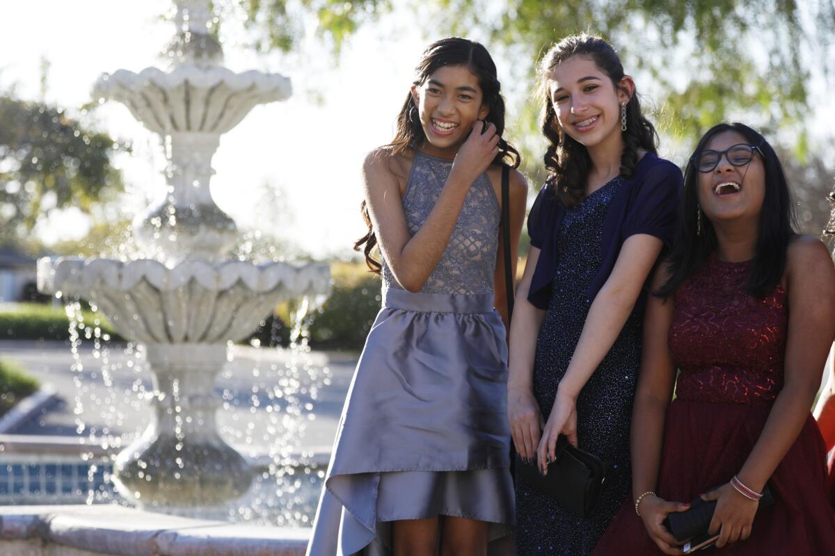 From left; Shanti Raminani, Mia Turel and Annsana Biju pose for photos before their dance at Almansor Court in Alhambra. All three are students at Cal State L.A. and participate in the Early Entrance Program. (Francine Orr / Los Angeles Times)