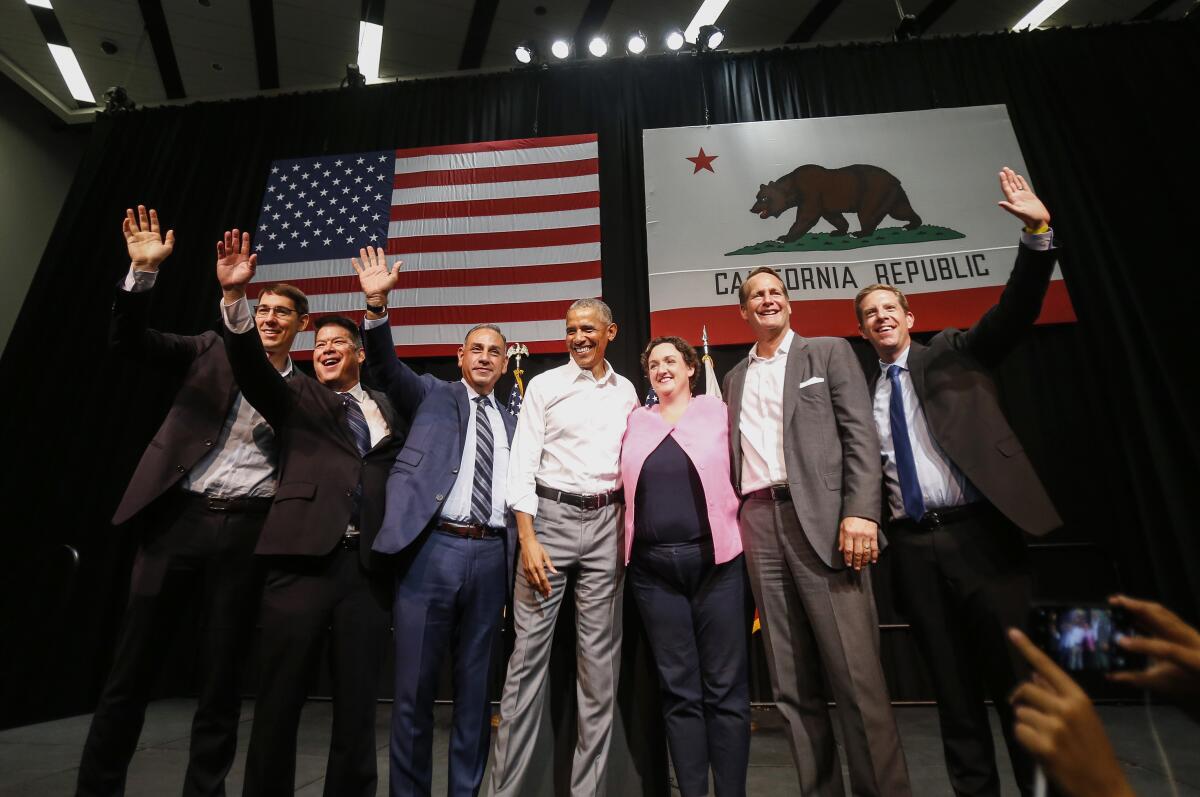 Former President Obama campaigns with then-congressional candidates, waving to supporters from an Anaheim stage. 