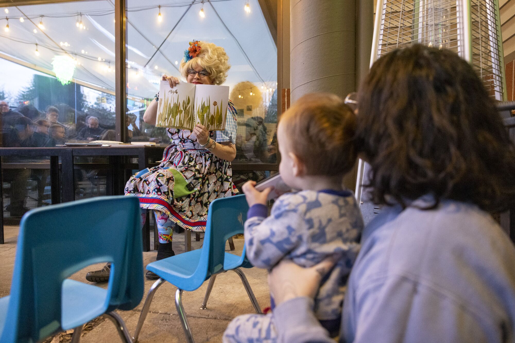 A woman and child listen as Sylvia O'Stayformore reads a book