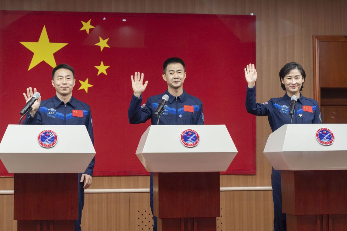 En esta imagen, distribuida por la agencia noticiosa Xinhua, los astronautas chinos (de izquierda a derecha) Cai Xuzhe, Chen Dong y Liu Yang, saludan durante una conferencia previa al lanzamiento de la misión Shenzhou-14, en el centro de lanzamiento satelital de Jiuquan, en el noroeste de China, el 4 de junio de 2022. (Cai Yang/Xinhua vía AP)