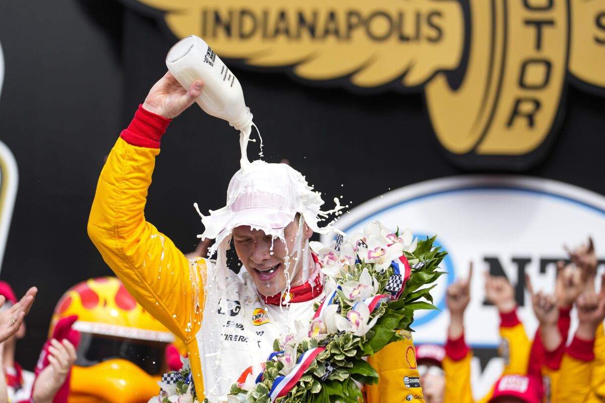 Josef Newgarden celebra vertiendo leche sobre su cabeza tras ganar las 500 Millas de Indianápolis el domingo 28 de mayo del 2023. (AP Foto/Michael Conroy)