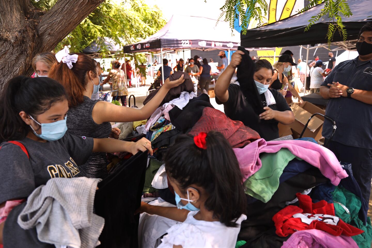 Watts residents pick out clothing during the Children Mending Hearts weekly food and clothing giveaway.