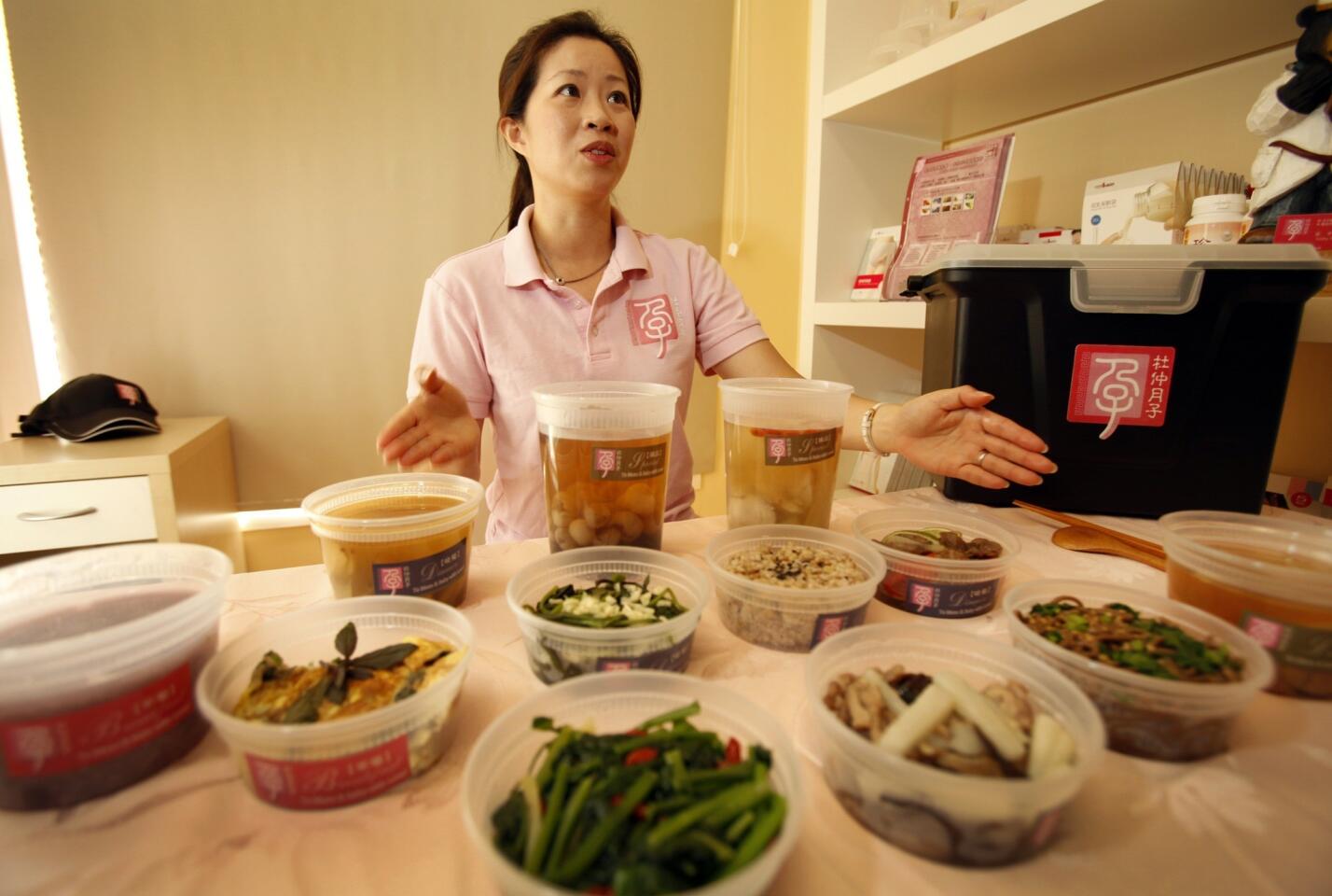 Charlotte Duh, owner of Meal4Mom, shows a few of the herbal soups and stews that she delivers to her postpartum clients from her Temple City studio.