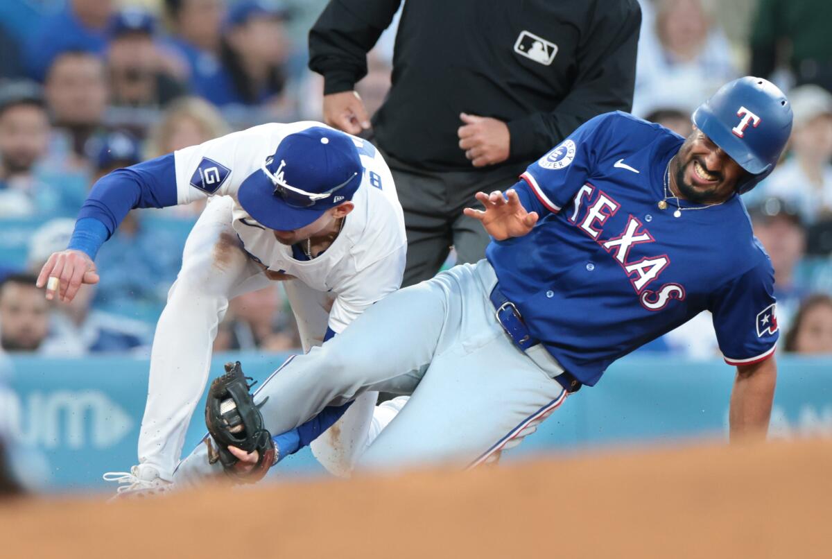 Dodgers third baseman Cavan Baggio tags out Texas baserunner Marcus Semien on a stolen base attempt.