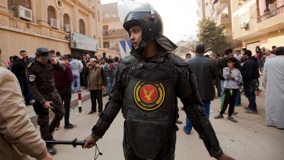 After several people were killed in a shootout, a policeman stands guard in front of the Coptic Orthodox Church of Mar Mina in Helwan, a southern suburb of Cairo, on Dec. 29.