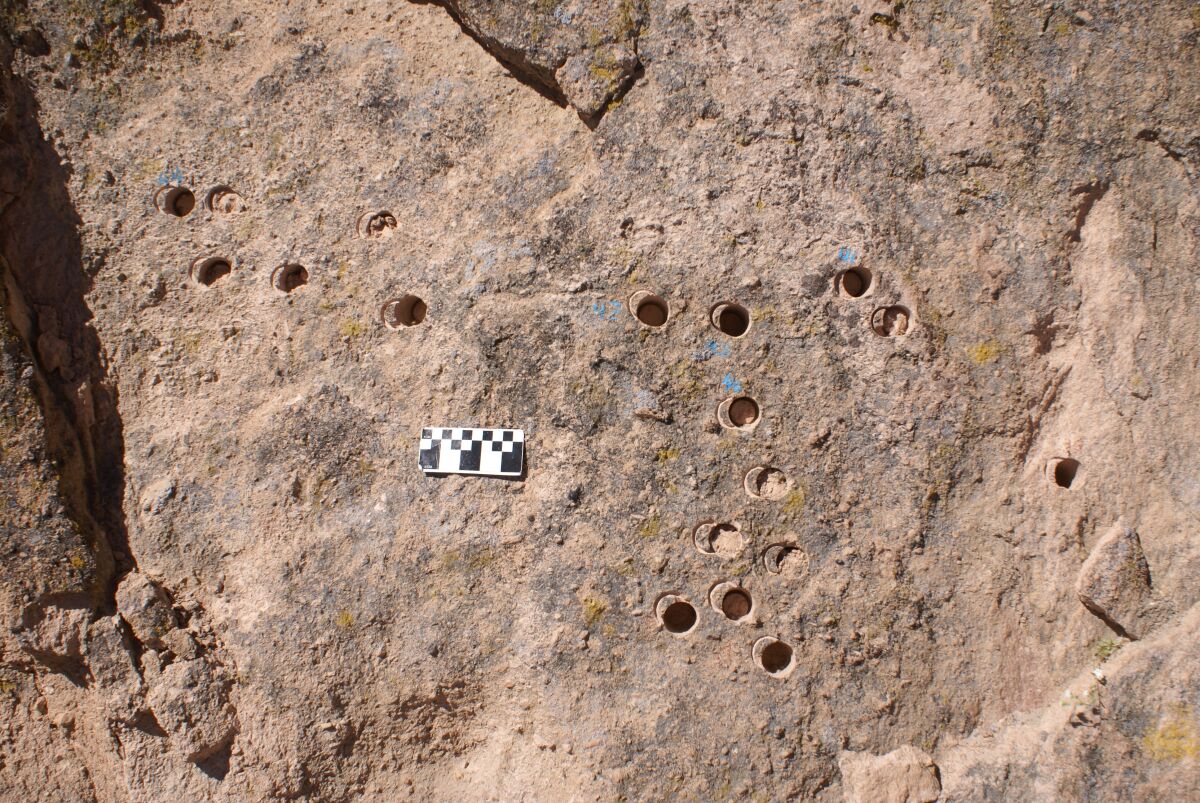 A photo of the damage caused by unauthorized drilling of core rock samples at a petroglyph site.