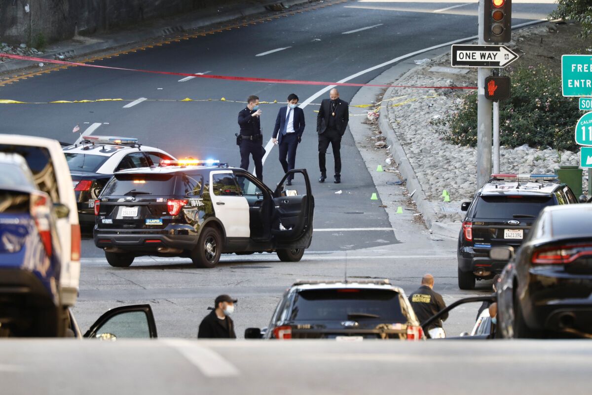 Members of law enforcement investigate the scene of a fatal police shooting.