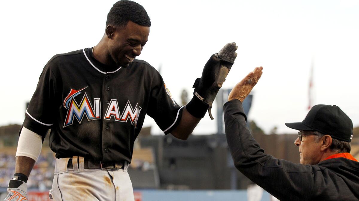 Marlins second baseman Dee Gordon is congratulated by Manager Don Mattingly after scoring against the Dodgers during their game Wednesday.