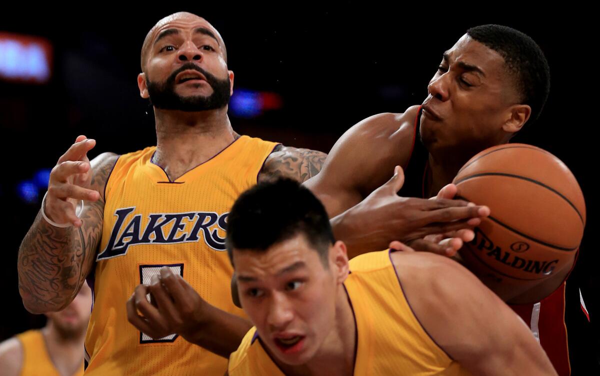 Miami center Hassan Whiteside pulls a rebound away from Carlos Boozer and Jeremy Lin during the second half. The Lakers lost to the Heat, 78-75, on Tuesday at Staples Center.