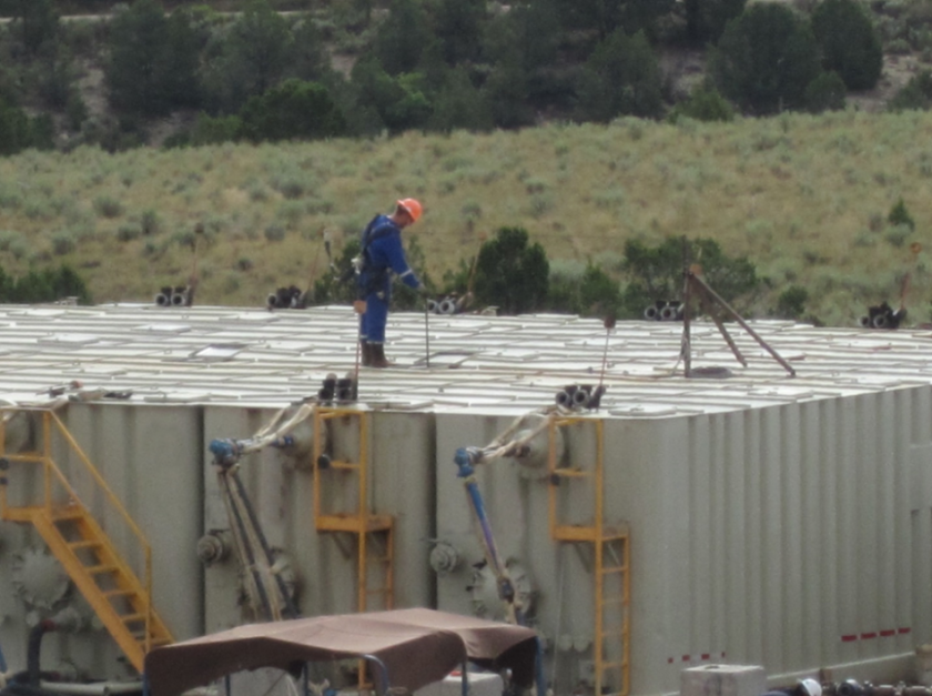 Oil field technician gauging a flowback tank. Workers check such tanks several times an hour, during which many are exposed to potentially dangerous amounts of the carcinogen benzene.