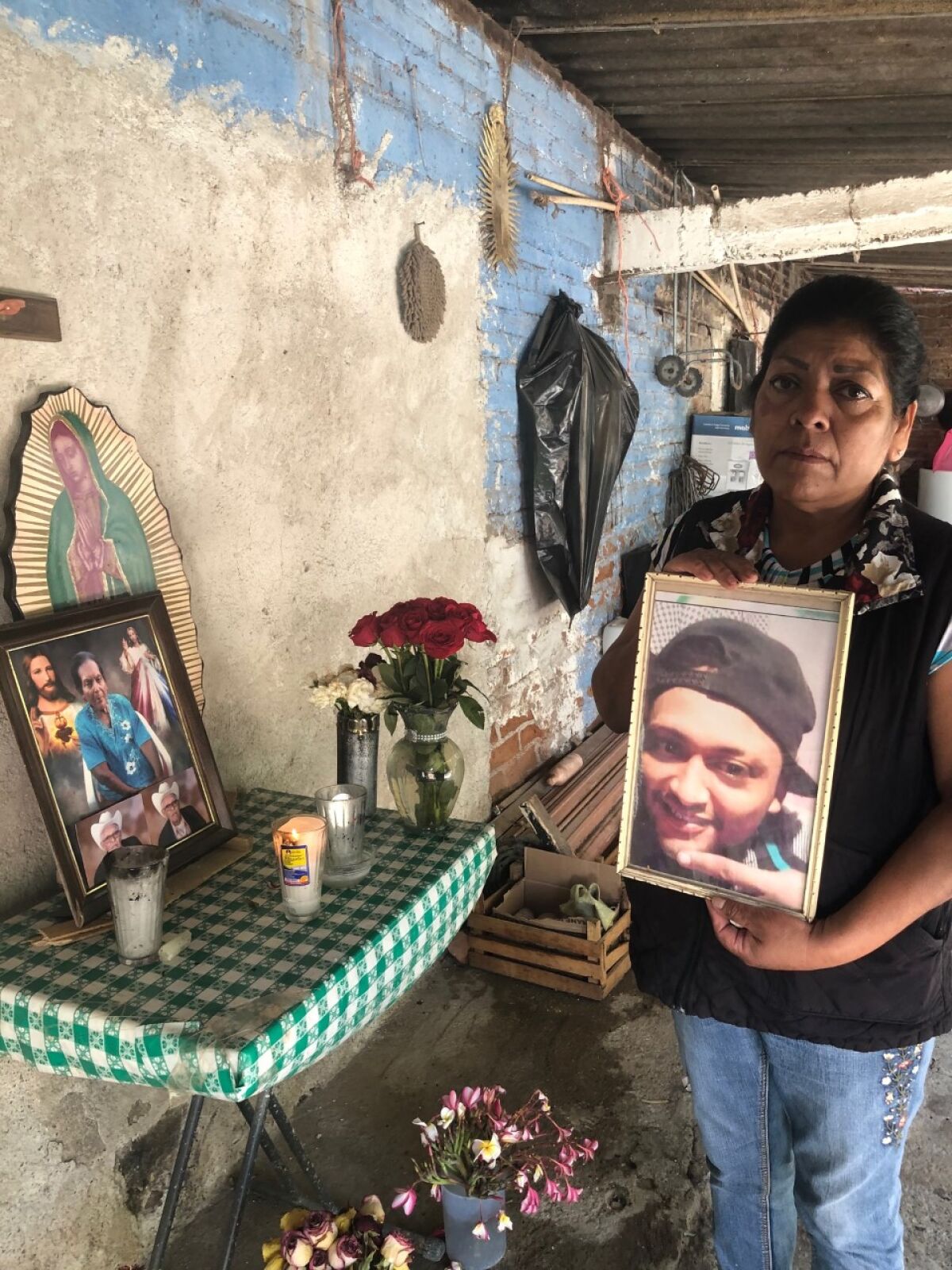 Natalia Acosta Medina pictured with photo of her son, Marco Antonio Castillo Medina, 31, who was also killed.