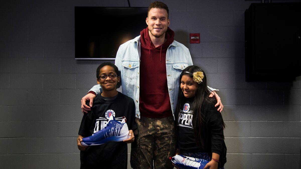 Clippers forward Blake Griffin spends moment with Nasir Lucas, 11, of Inglewood, and Miranda Morales, 10 of Los Angeles, who are the recipients of eye glasses donated by Griffin on Saturday at Staples Center.