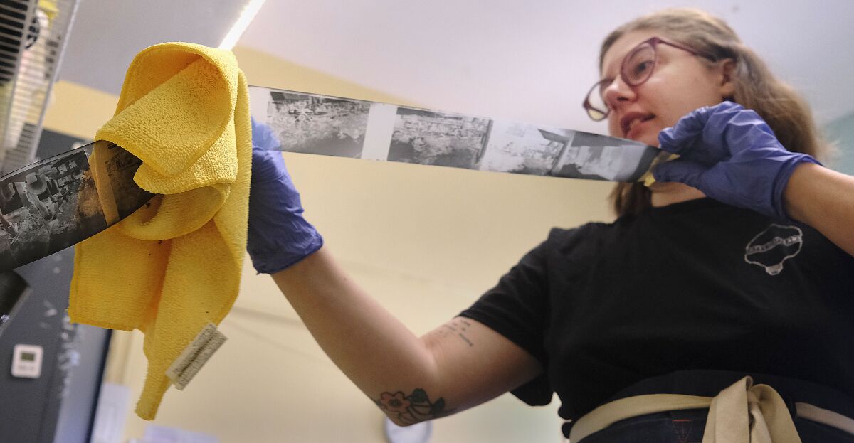 Photo lab manager Caiti Borruso wipes water from film negatives at Camera Exposure & Safelight Lab in North Park. 
