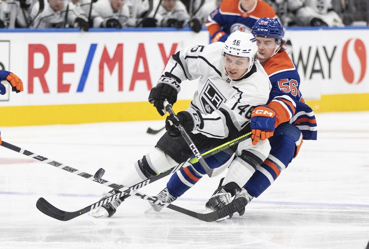 L'attaquant des Kings Blake Lizotte et l'attaquant des Oilers d'Edmonton Kailer Yamamoto se battent pour la rondelle.