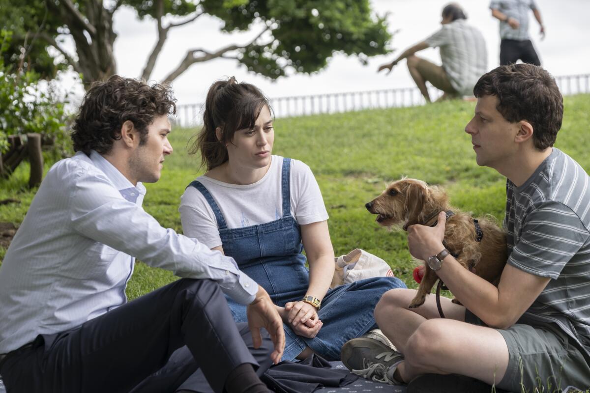 Three friends sitting in the park with a dog