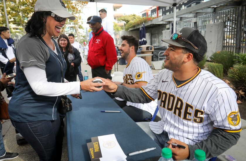 Padres outfielder Trent Grisham, right, is all smiles after signing an autograph for Veronica Gonzalez of Chula Vista, during Padres FanFest 2020.
