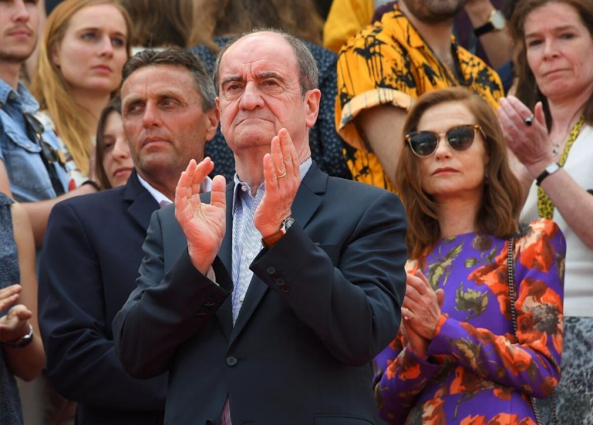 President of the Cannes Film Festival Pierre Lescure, left, and actress Isabelle Huppert applaud after they observed a minute of silence for victims of the Manchester bombing.